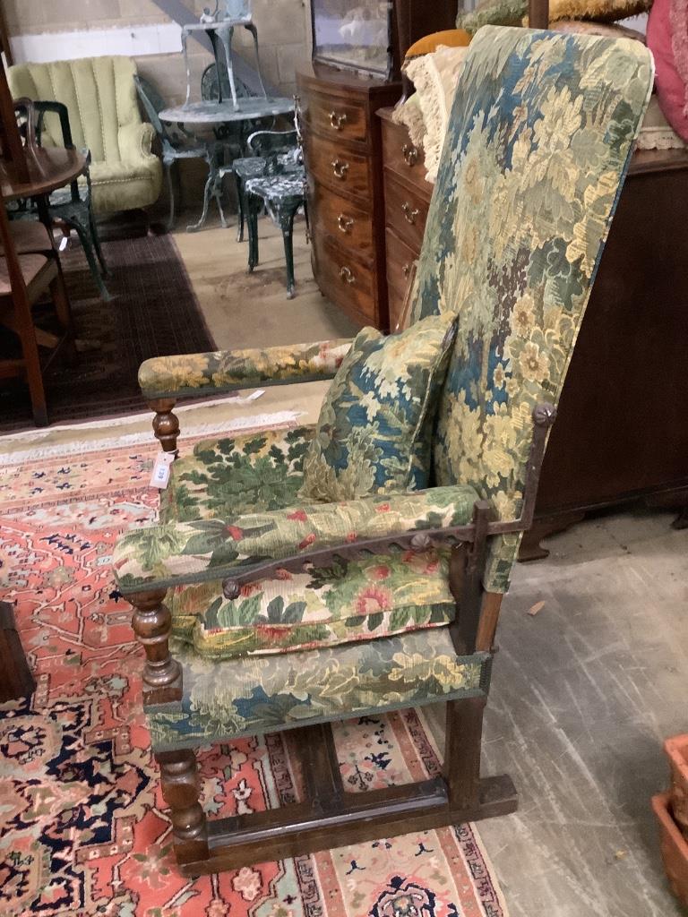 A Jacobean style carved walnut reclining armchair, with tapestry upholstery, width 68cm depth 60cm height 122cm